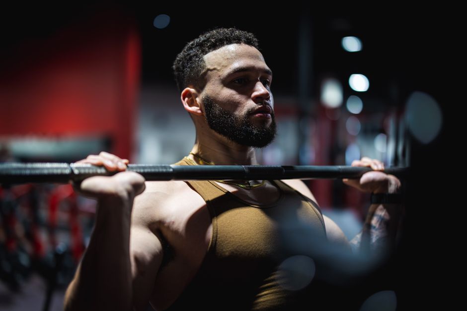 Muscular man in a gym focused on lifting a barbell