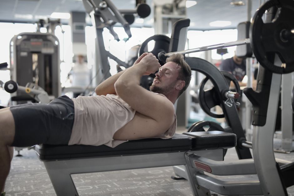 Focused muscular sportsman preparing to workout with heavy barbell